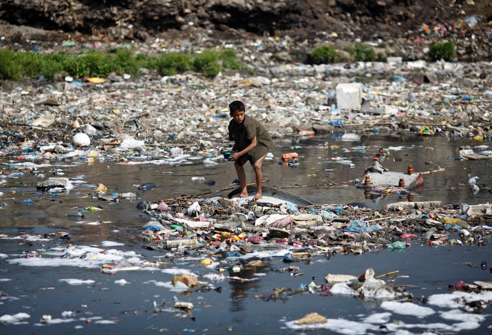 A boy looks for plastic bottles at the polluted Bagmati River in Kathmandu March 22, 2013. REUTERS/Navesh Chitrakar/File Photo Climate change - biodiversity - pollution