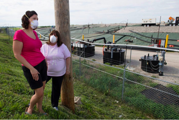 Activists Dawn Chapman, left, and Karen Nickel wear protective masks at the West Lake Landfill in Bridgeton, Mo., north of St. Louis. The site, part of which is listed as among the nation's most toxic messes, includes radioactive waste illegally dumped in the 1970s. (Linda Davidson/The Washington Post)